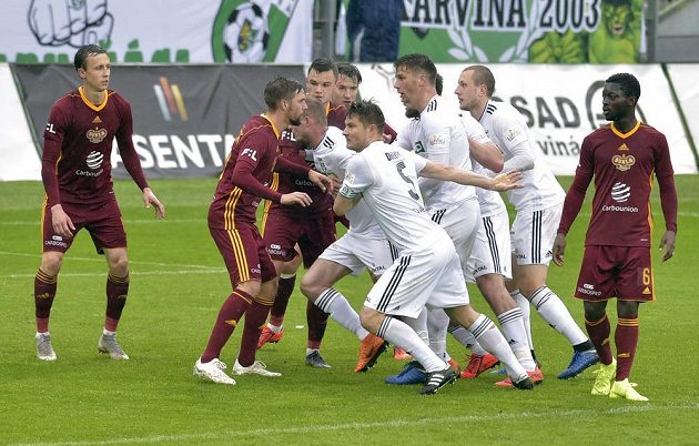 Fotbalisté Karviné (v bílých dresech) a Dukly bojují o výhodnou pozici před brankou pražského týmu v utkání nejvyšší soutěže.
