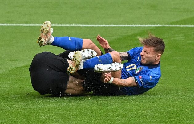Rakouský brankář Daniel Bachmann leží na trávníku po střetu s Italem Cirem Immobilem v osmifinále EURO.