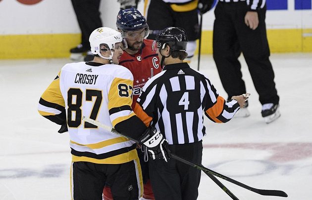 Hvězdy v akci. Lídr Pittsburghu Penguins Sidney Crosby (87) a ruský útočník Washingtonu Capitals diskutují s rozhodčím během utkání NHL.