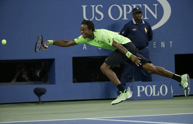 Gael Monfils z Francie se marně snaží dohonit balónek v zápase s Rogerem Federerem z Francie.