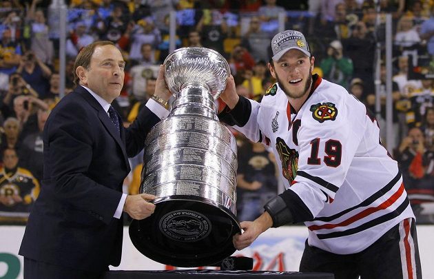 Kapitán Chicaga Jonathan Toews přebírá od komisionáře NHL Garyho Bettmana Stanley Cup.