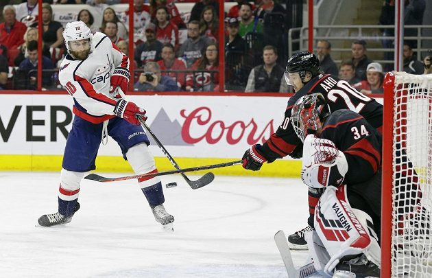 Hokejista Brett Connolly (10) z Washingtonu Capitals překonává Petra Mrázka v brance Caroliny Hurricanes v utkání 1. kola play off.