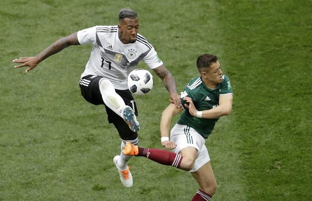 Německý obránce Jerome Boateng odehrává míč před Javierem Hernándezem z Mexika.