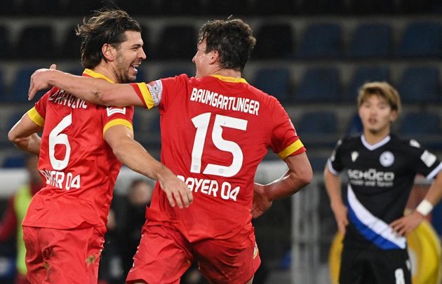 Aleksandar Dragovic (vlevo) nakonec zařídil výhru pro Leverkusen, minela brankáře Lukáše Hrádeckého tým nakonec nestála žádné body. Vpravo Julian Baumgartlinger.
