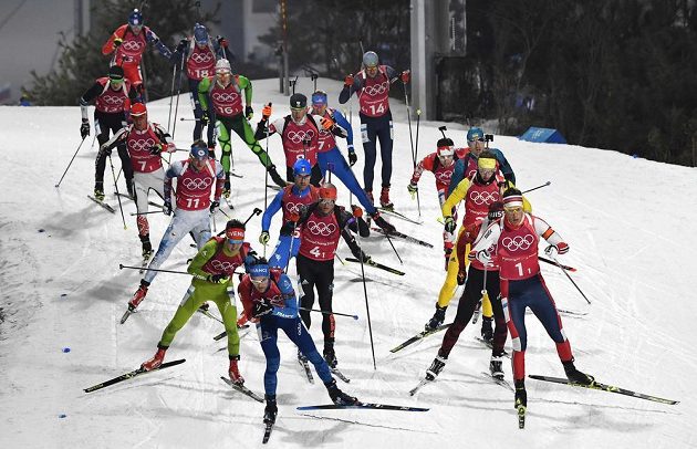 Balík biatlonistů při prvním úseku mužské štafety. Český reprezentant Ondřej Moravec (třetí zleva) jel s číslem 11.