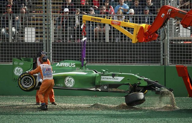Jeřáb odnáší poškozený monopost stáje Caterham, který řídil Japonec Kamuj Kobajaši.