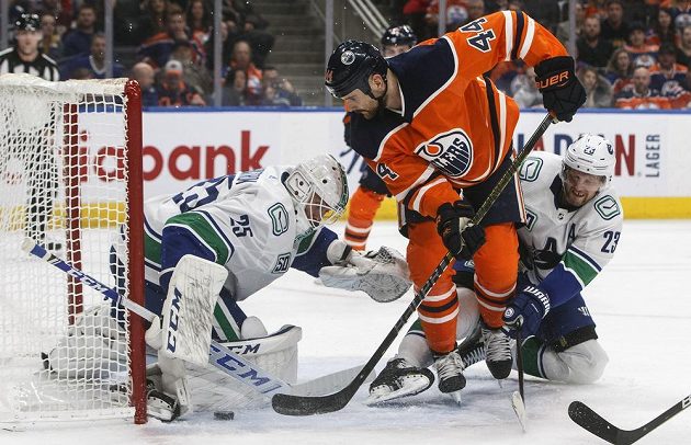 Gólman Vancouveru Markstrom (vlevo) při zákroku proti dorážce Kassiana z Edmontonu.