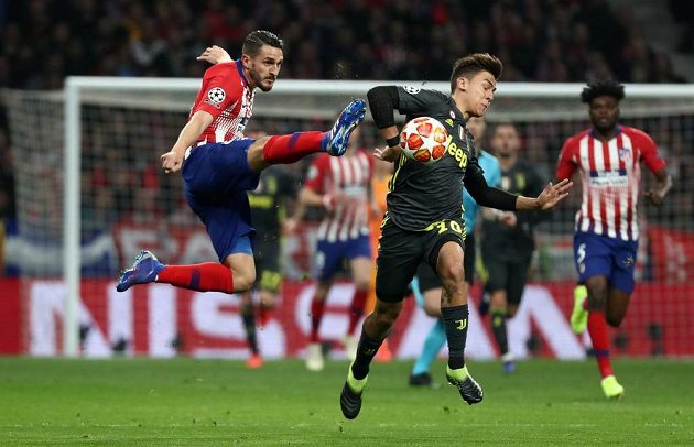 Koke (vlevo) z Atlétika Madrid se snaží zastavit unikajícího Paula Dybalu z Juventusu.