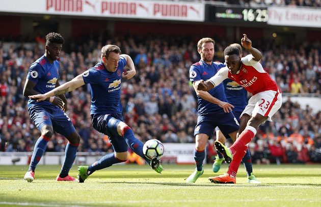 Fotbalista Manchesteru United Phil Jones blokuje střelu Dannyho Welbecka z Arsenalu během šlágru Premier League.
