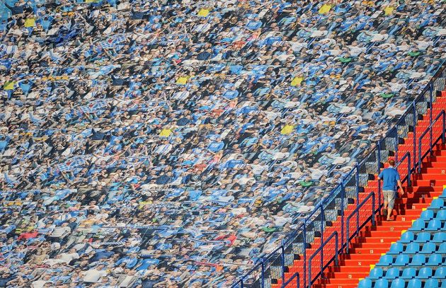 Jeden z příznivců prochází kolem obří fotografie fanoušků, kterou na tribunu na Bazalech umístil klub.