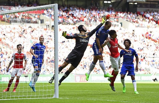 Gólman Arsenalu Petr Čech vyráží míč před naskakujícím obráncem Chelsea Branislavem Ivanovičem.