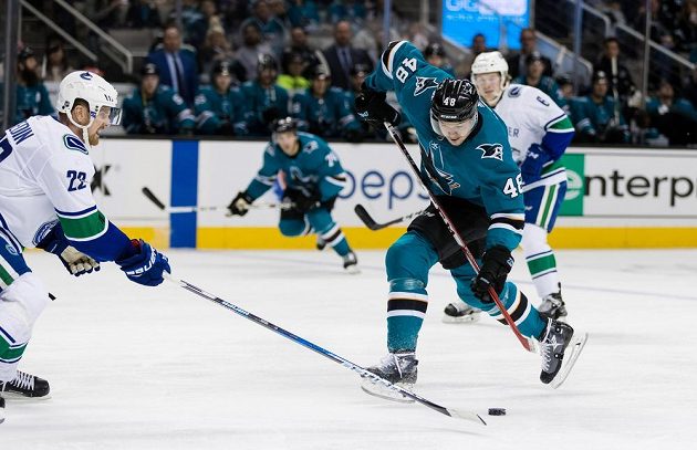 Útočník San Jose Sharks Tomáš Hertl se pokouší zakončit přes bránícího Daniela Sedina z Vancouveru v utkání NHL.