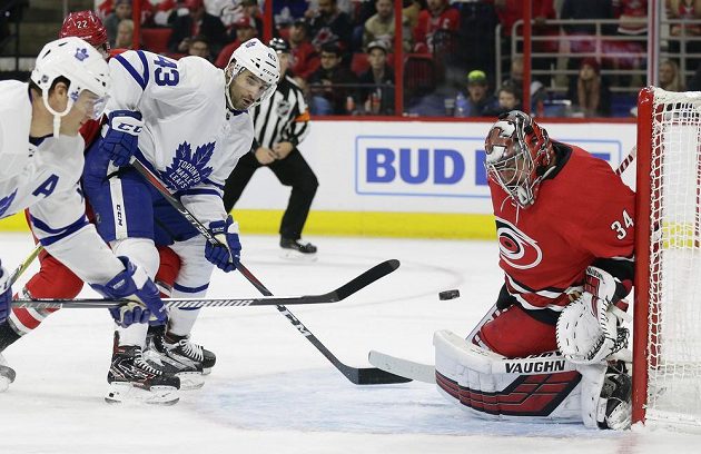 Hokejisté Toronta Maple Leafs Patrick Marleau a Nazem Kadri se snaží vyzrát na Petra Mrázka v brance Caroliny v utkání NHL.