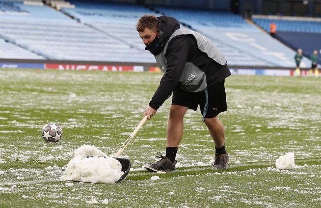 Pracovník technické čety odklízí následky krupobití, které se sneslo na trávník Etihad Stadium před odvetným utkáním semifinále Ligy mistrů.