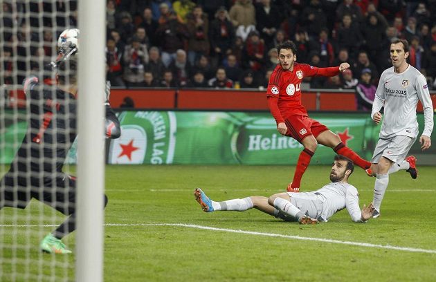 Leverkusenský Hakan Calhanoglu (uprostřed) překonává brankáře Atlétika Miguela Angela Moyu (vlevo) v úvodním osmifinále Ligy mistrů.