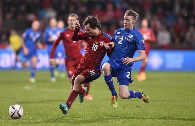 Tomáš Rosický (vlevo)a Birkir Saevarsson z Islandu během utkání kvalifikace ME 2016 v Plzni.