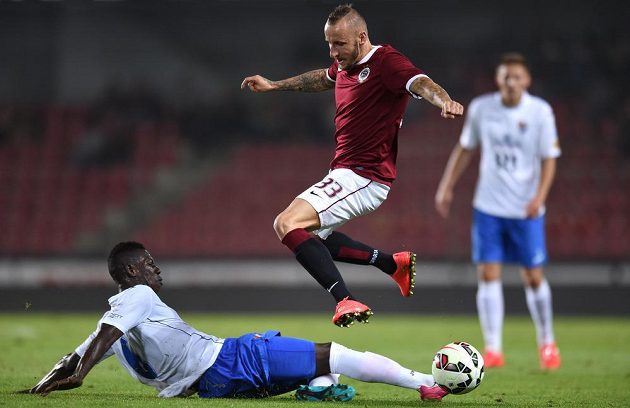 Derrick Mensah z Baníku Ostrava (vlevo) odehrává míč před sparťanským záložníkem Michalem Breznaníkem.