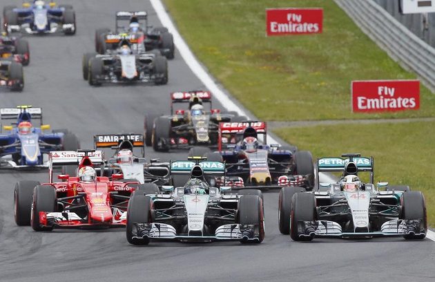 Nico Rosberg se svým mercedesem předjíždí v úvodní zatáčce GP Rakkouska svého týmového kolegu Lewise Hamiltona (vpravo).