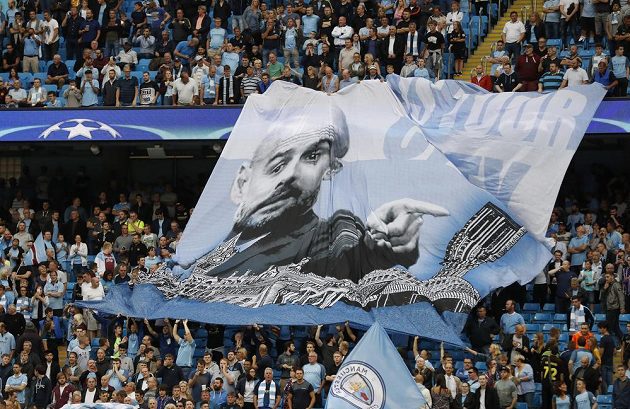 Fanoušci Manchesteru City drží transparent s podobiznou kouče Pepa Guardioly během odvety play off Ligy mistrů.