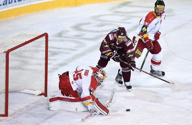 Sparťanský útočník Jaroslav Hlinka (uprostřed) se snaží překonat olomouckého brankáře Jiřího Trvaje.