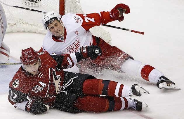 Parvé křídlo Arizony Coyotes Radim Vrbata (17) padá při souboji s Dylanem Larkinem z Detroitu Red Wings během utkání NHL.