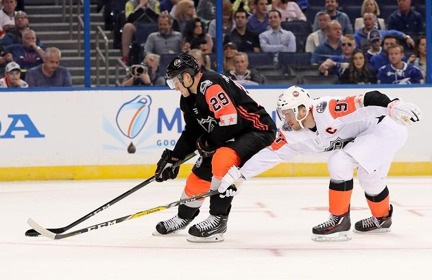 Útočník Connor McDavid (vpravo) se v barvách výběru Pacifické divize snaží vypíchnout puk Nathanu MacKinnonovi při Utkání All Star Game NHL.