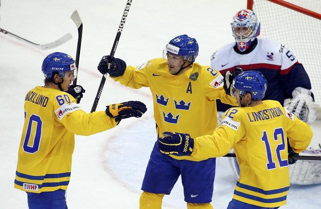 Švédští hokejisté slaví gól proti Slovensku. Zleva střelec branky Mikael Backlund, Jimmie Ericsson a Joakim Lindström. Vzadu je smutný brankář Ján Laco.