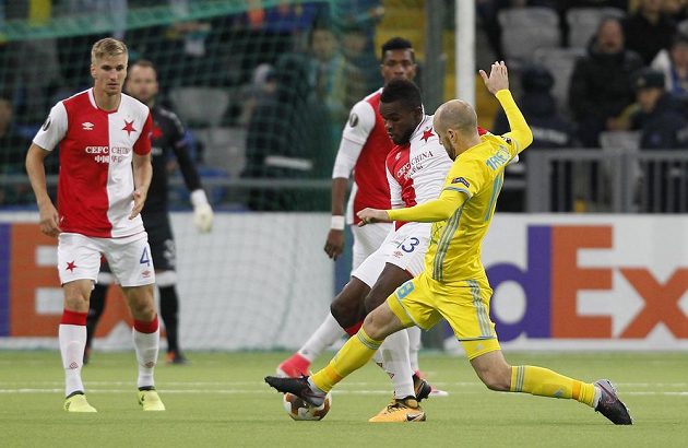 Fotbalista Slavie Michael Ngadeu-Ngadjui v souboji s Ivanem Majevským z Astany v utkání Evropské ligy.