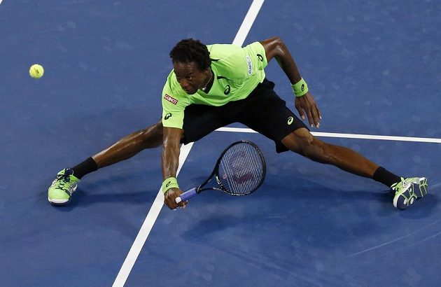 Gael Monfils z Francie v krkolomné pozici sleduje míček v zápase s Rogerem Federerem ze Švýcarska.