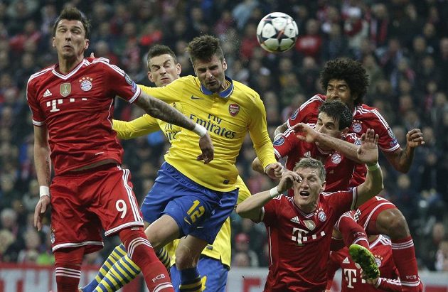 Fotbalista Arsenalu Oliver Giroud (uprostřed) hlavičkuje v obležení hráčů Bayernu Mnichov v odvetě osmifinále Ligy mistrů.
