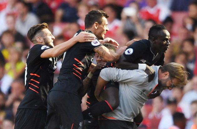 Liverpoolští fotbalisté oslavují s koučem Jürgenem Kloppem gól proti Arsenalu.