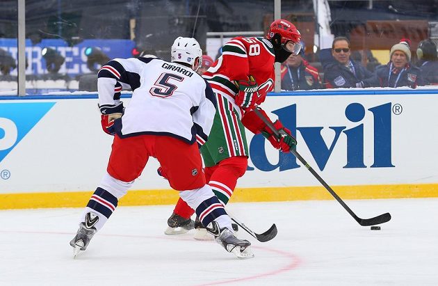 Obránce NY Rangers Dan Girardi (5) dotírá na Jaromíra Jágra z New Jersey Devils v utkání pod širým nebem.