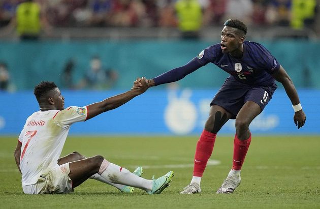 Frenchman Paul Pogba helps Breel Embolov from Switzerland to his feet.