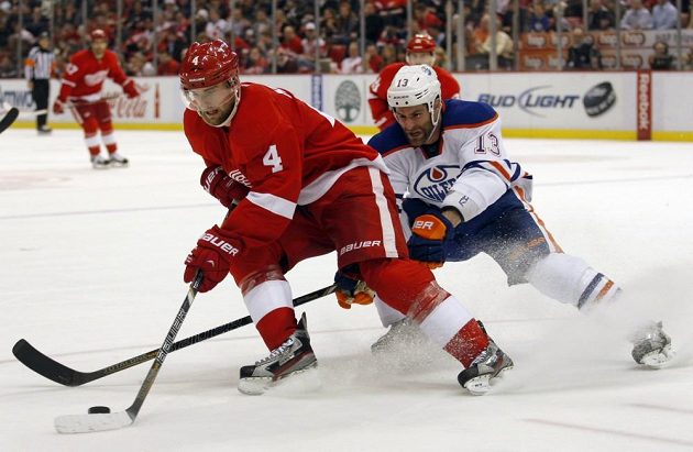 Obránce Detroitu Jakub Kindl (vlevo) drží puk před útočníkem Edmontonu Mikem Brownem.