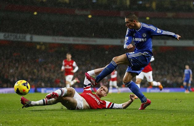 Stoper Arsenalu Per Mertesacker (na zemi) ve skluzu zastavil střelu Fernanda Torrese z Chelsea.