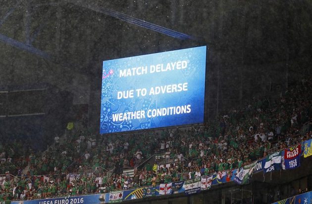 Světlená tabule na stadiónu v Lyonu oznamuje, že utkání Ukrajiny se Severním Irskem je kvůli nepřízni počasí přerušeno.