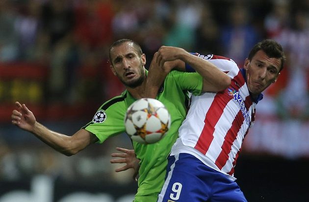 Obránce Juventusu Giorgio Chiellini (vlevo) bojuje o míč útočníkem Atlétika Madrid Mandžukičem.