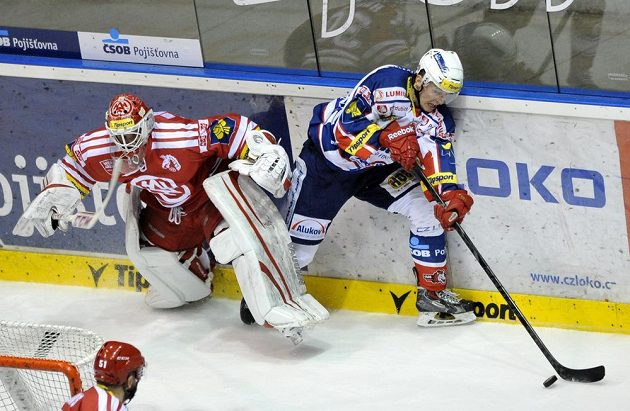 Třinecký gólman Šimon Hrubec spěchá rychle do branky, než Lukáš Radil z Pardubic využije jeho zaváhání.