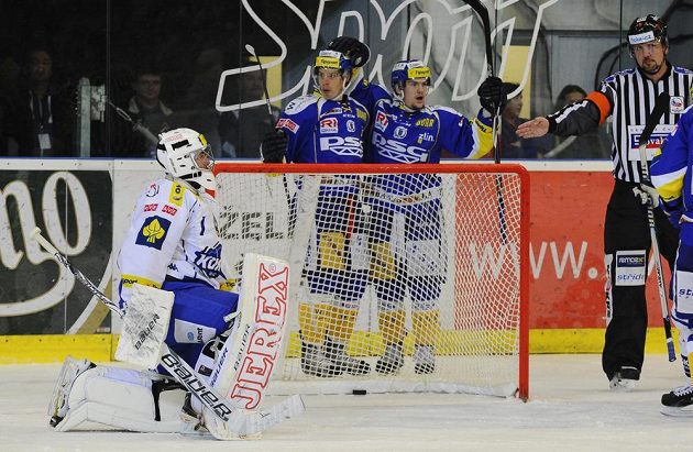 Zlínští útočníci Roman Vlach (vzadu vlevo) a Petr Holík slaví gól v síti Brna. Vlevo je smutný brankář Komety Marek Čiliak.