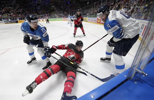 Finále hokejového MS v plném proudu. V souboji u mantinelu Kanaďan Anthony Cirelli mezi Finy Juhani Tyrvainenem a Mikko Lehtonenem (vpravo).