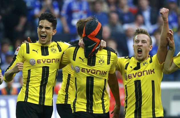 Maskovaný dortmundský střelec Pierre-Emerick Aubameyang slaví se spoluhráči gól v síti Schalke.