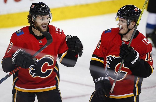Český útočník Michael Frolik (vlevo) oslavuje svoji trefu proti Coloradu se spoluhráčem z Calgary Matthewem Tkachukem.