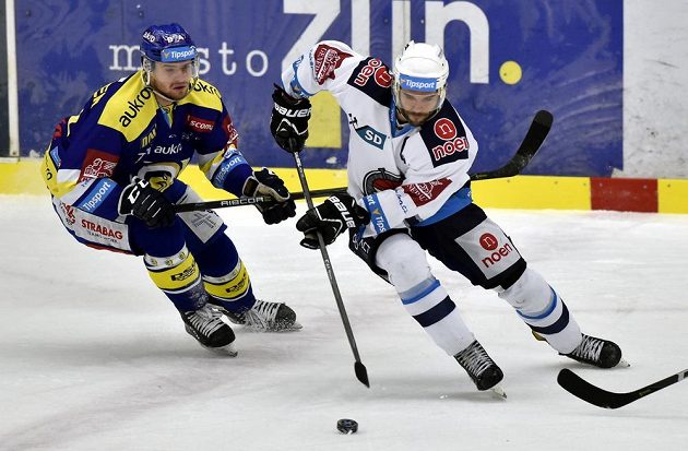 Pavel Sedláček ze Zlína a Michal Vondrka z Chomutova bojují o puk během extraligového utkání.