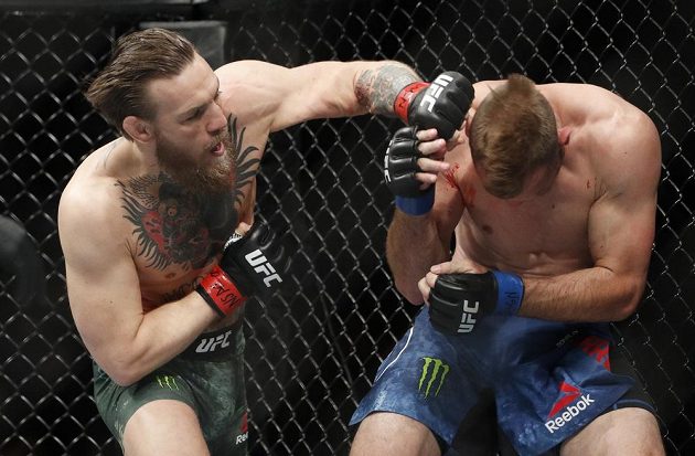 Conor McGregor (vlevo) zasypává svého soupeře Donalda Cerroneho sprškou ran v postoji při zápase organizace UFC.