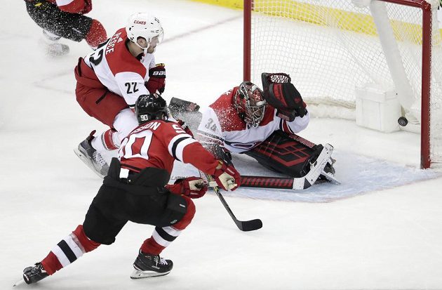 Útočník New Jersey Devils Marcus Johansson (90) překonává českého gólmana v brance Caroliny Petra Mrázka (34).