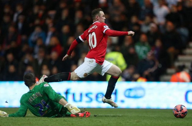 Útočník Manchesteru United Wayne Rooney v souboji s brankářem Prestonu Thorstenem Stuckmannem.