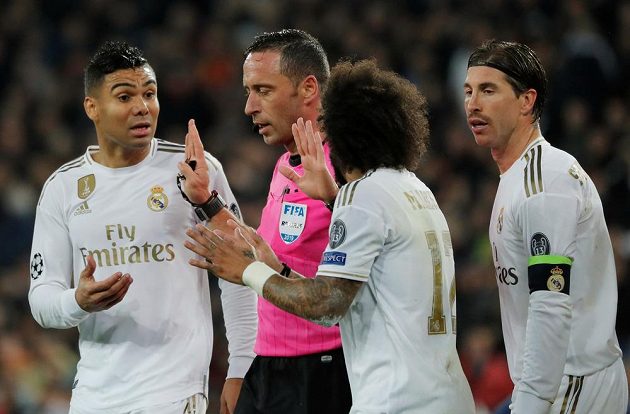 Fotbalisté Realu Madrid diskutují během utkání Ligy mistrů s rozhodčím Arturem Soaresem Diasem.
