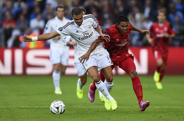 Obránce Realu Madrid Pepe (vlevo) zasahuje před Kolumbijcem Carlosem Baccou ze Sevilly.