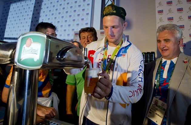 Judista Lukáš Krpálek točí pivo v Českém domě na oslavu své zlaté medaile. Vpravo je předseda Senátu Milan Štěch.