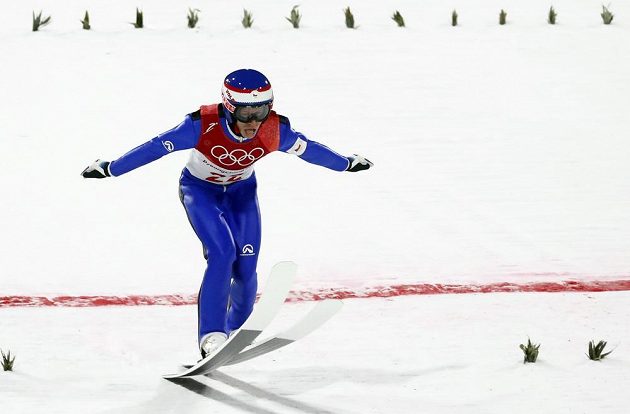Český skokan na lyžích Roman Koudelka při doskoku během závodu na středním můstku.